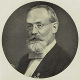 Halftone portrait in an oval frame of Will S. Monroe, an older man with white hair, round wire-rimmed glasses and a full white beard and mustache, in a dark suit with a light bow tie; the printed Czech caption below reads "Prof. W. S. Monroe z Montclairu."